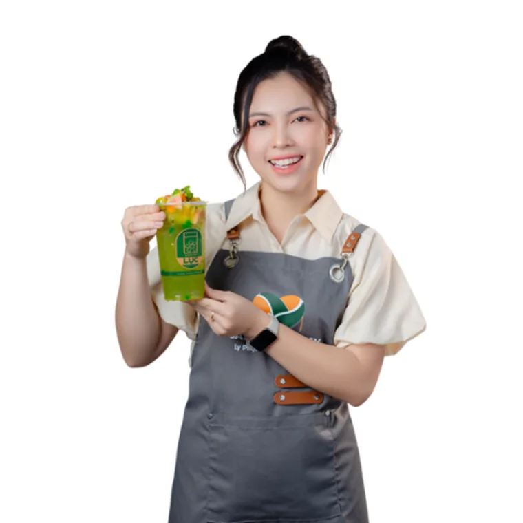 Giảng viên Ly Phạm trong đồng phục Saly Academy, cầm ly trà trái cây thành phẩm